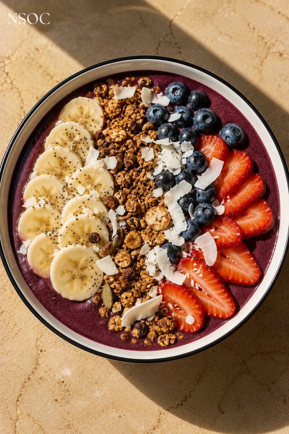 Vertical Pinterest pin of an acai berry smoothie bowl with banana and granola, an example of NSOC campaign food photography