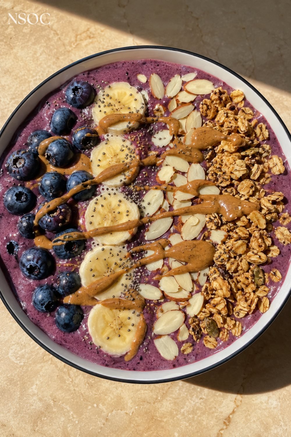 Vertical Pinterest pin of a blueberry almond butter smoothie bowl