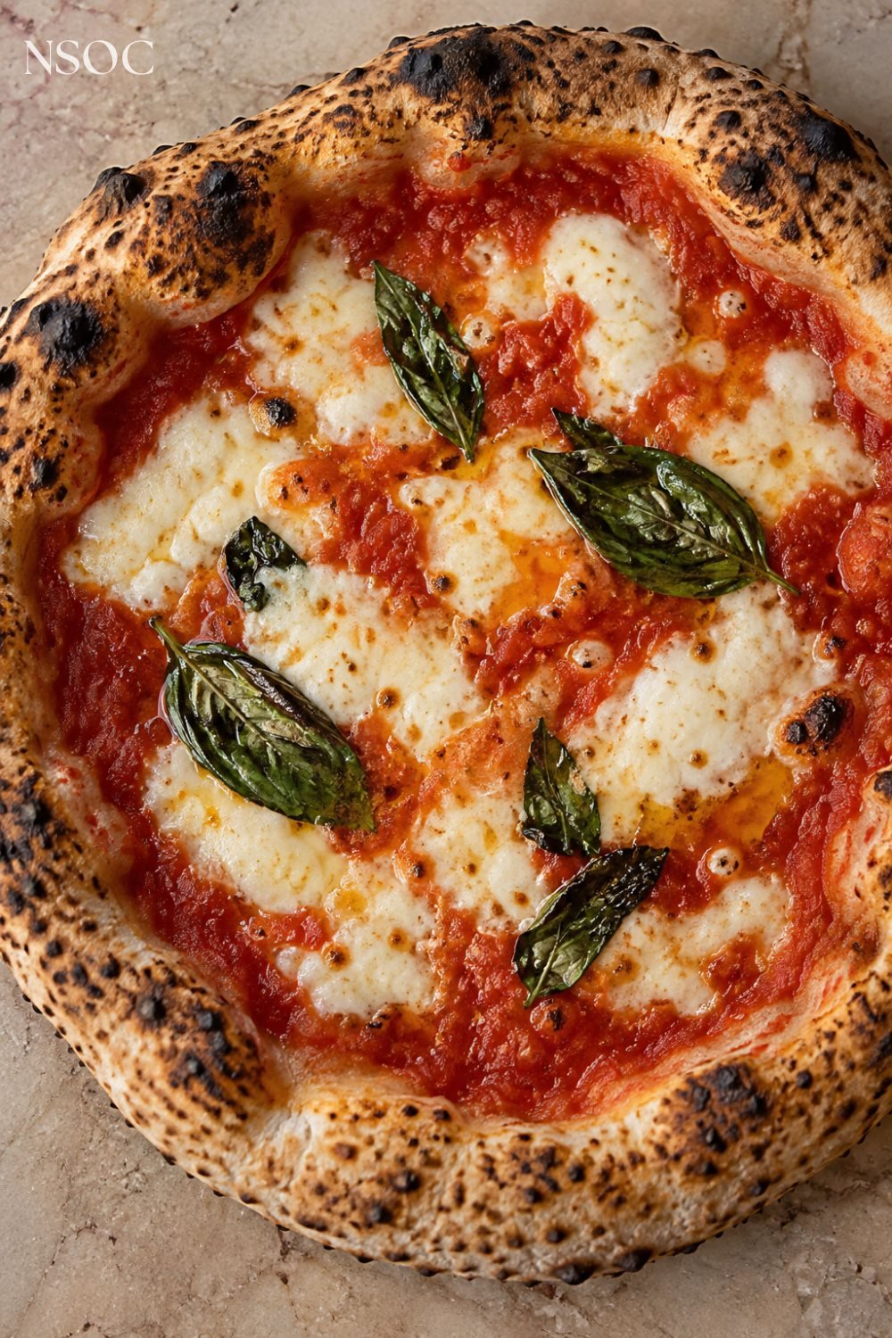 Vertical Pinterest pin of a wood-fired Neapolitan margherita pizza with fresh basil, an example of NSOC campaign food photography