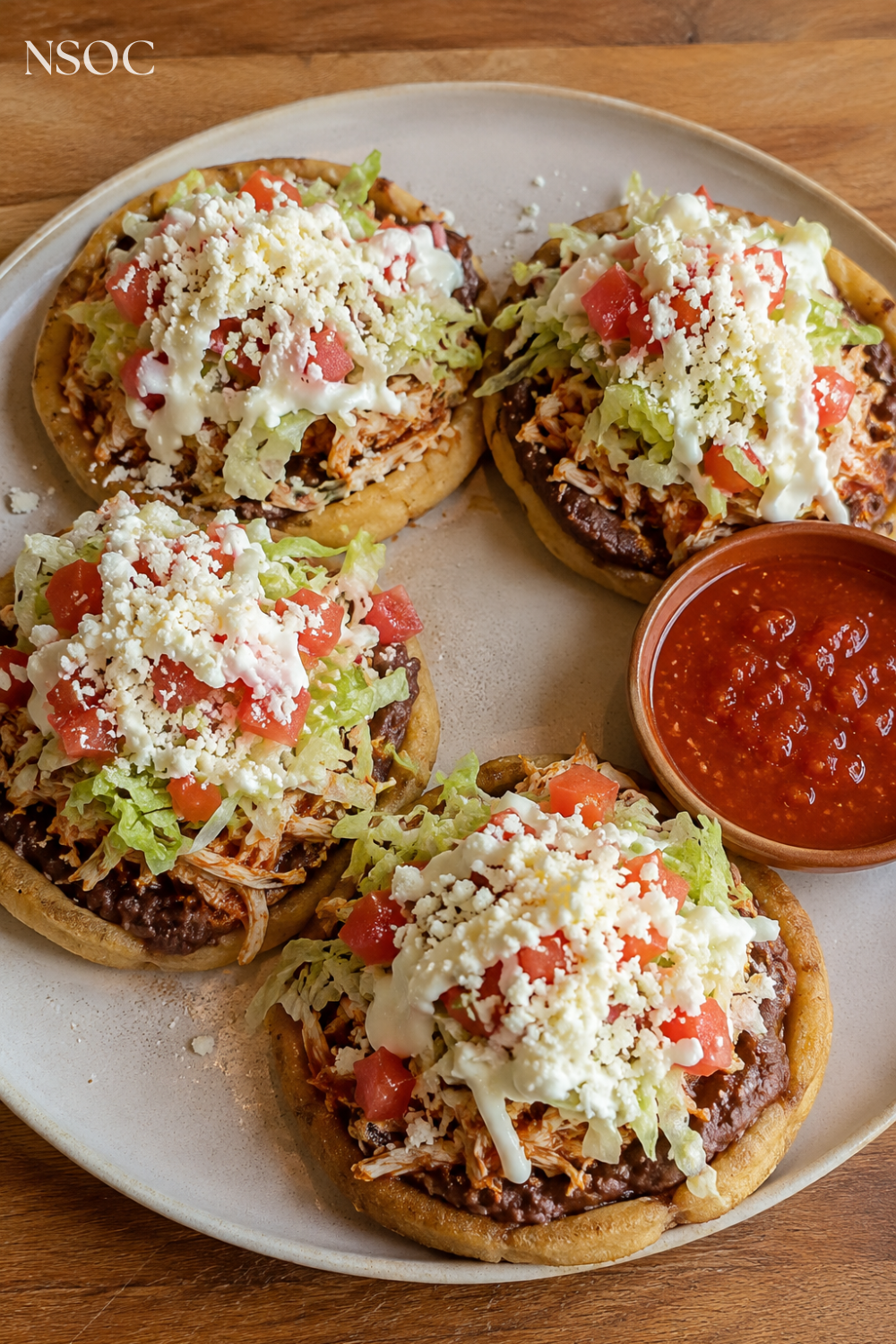 Vertical Pinterest pin of sopes topped with refried beans, shredded chicken and cotija cheese