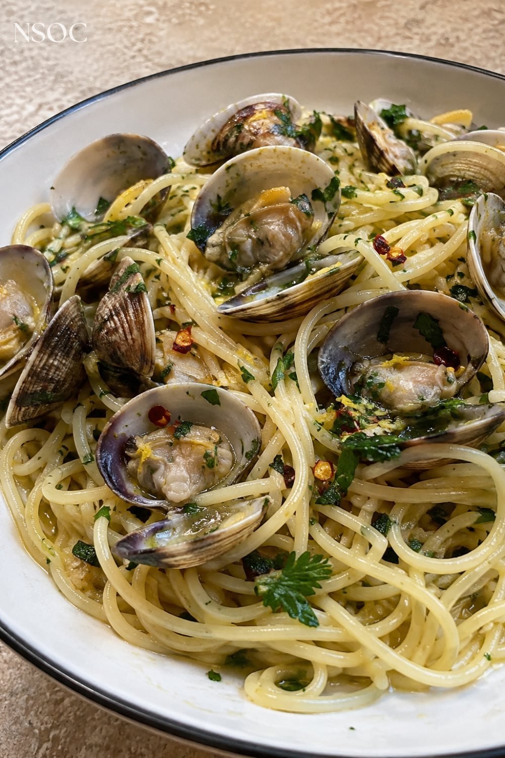 Vertical Pinterest pin of spaghetti alle vongole tossed in olive oil
