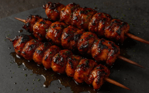 honey sriracha grilled chicken skewers brushed with glaze on outdoor grill