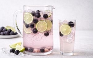 pitcher of blackberry lime infused water with whole berries and lime slices