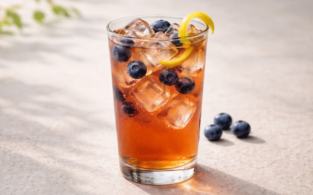 blueberry black iced tea served over ice with fresh blueberries and lemon peel twists