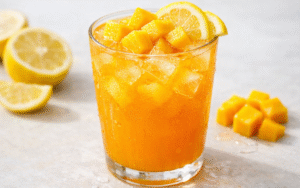 fresh mango lemonade with ice, lemon slices, and mango cubes