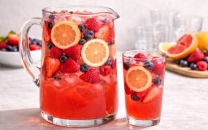 mixed berry citrus pitcher drink with ice and fresh berries