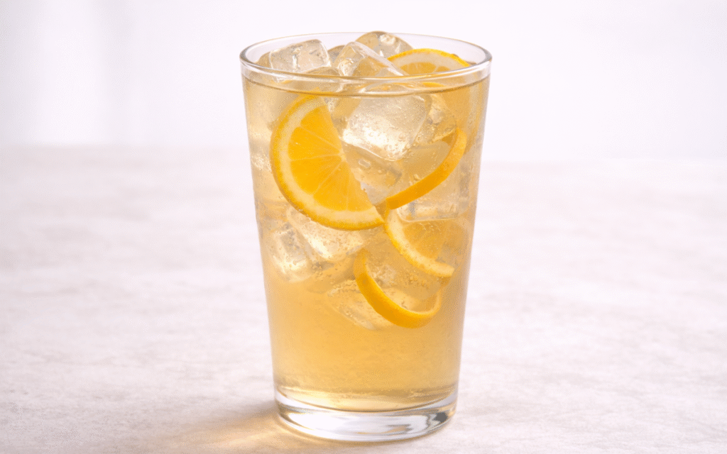 orange jasmine iced tea served over ice with orange peel twist