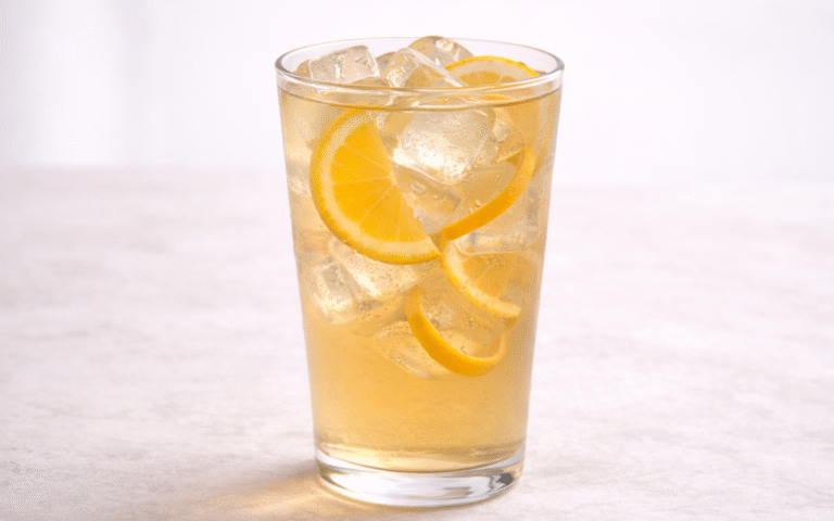 orange jasmine iced tea served over ice with orange peel twist