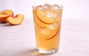peach jasmine iced tea served over ice with fresh peach slices