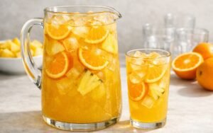 pineapple orange pitcher drink with ice and fresh fruit