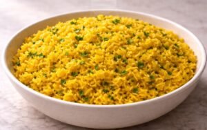 Bowl of bright golden yellow turmeric rice garnished with fresh parsley