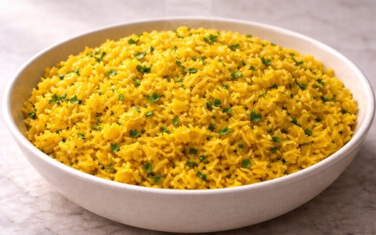 Bowl of bright golden yellow turmeric rice garnished with fresh parsley