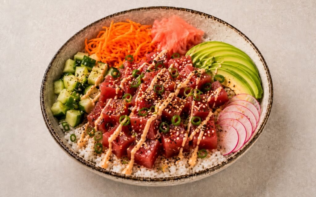 Close-up of fresh tuna poke bowl showing marinated ahi tuna cubes, colorful vegetables, and sesame seeds on seasoned rice