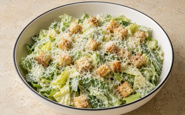 Authentic Caesar side salad with romaine lettuce, Parmesan cheese, and croutons on a white plate