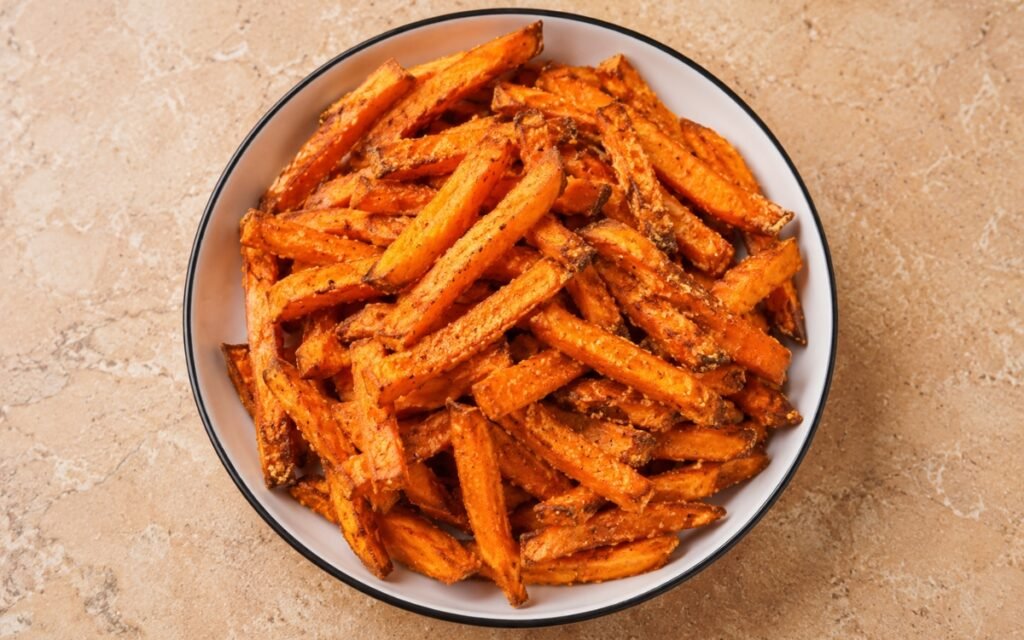 Crispy sweet potato fries golden and seasoned on a baking sheet