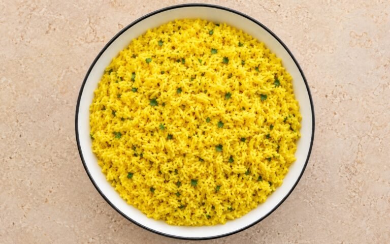 Garlic turmeric yellow rice golden and fluffy garnished with fresh parsley
