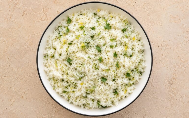 Greek lemon rice fluffy and garnished with fresh herbs and lemon zest
