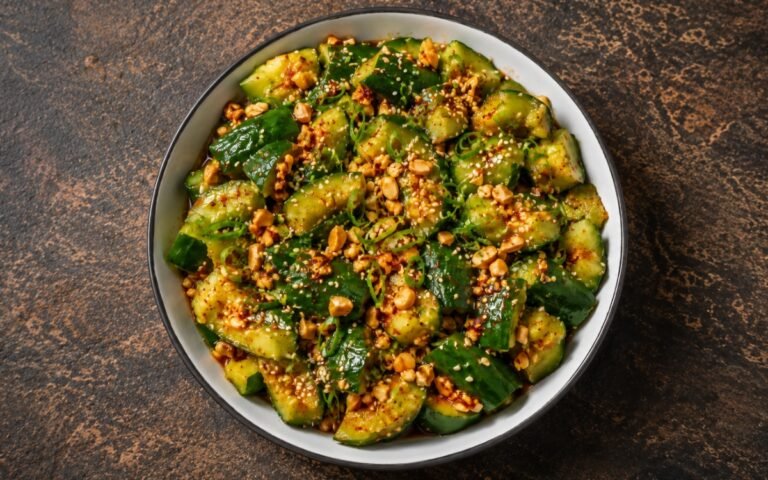 Spicy smashed Asian cucumber salad with chili oil and sesame seeds in a bowl